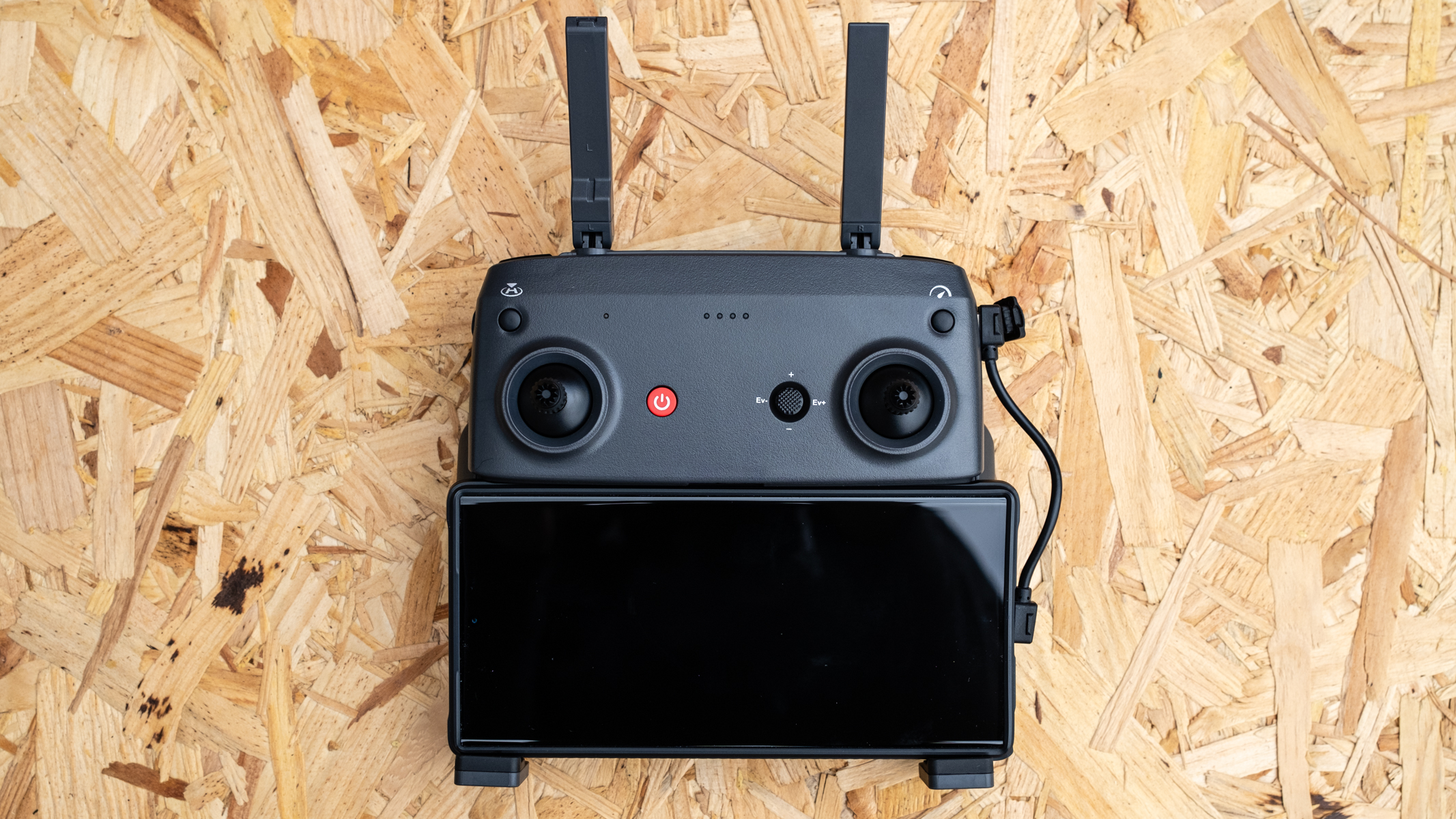 Holy Stone HS900 controller with a smartphone attached on a wooden surface