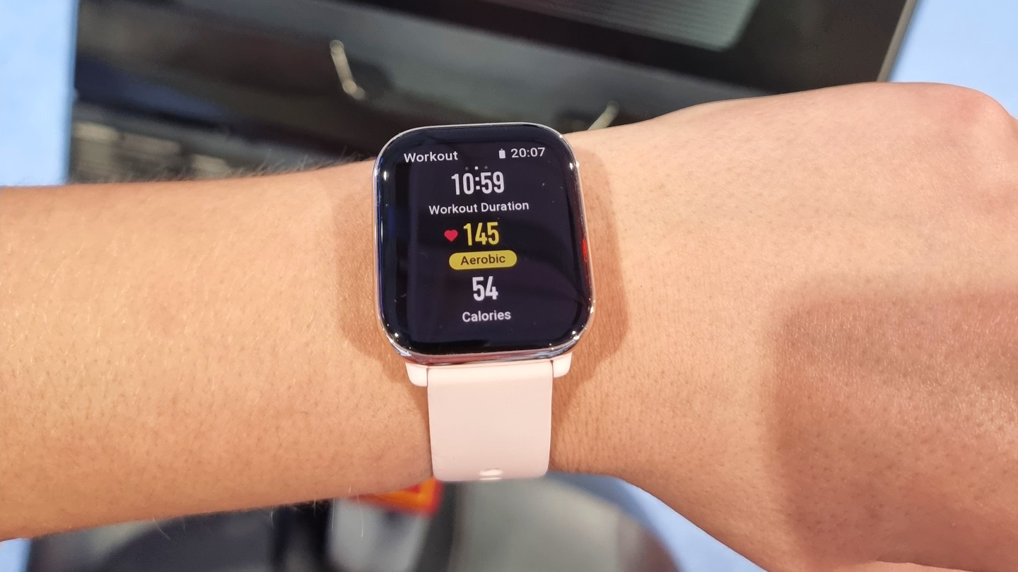 Our reviewer wearing the Amazfit Active watch showing the workout screen.