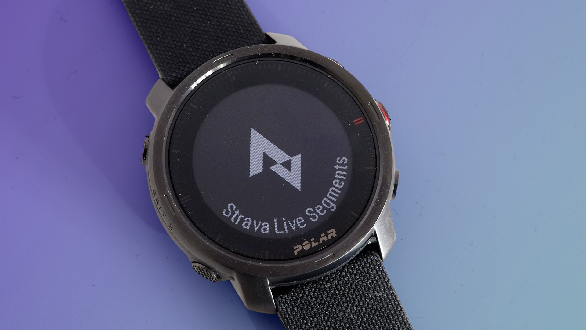 The Polar Grit X on a purple background displaying the Strava Live segments screen.